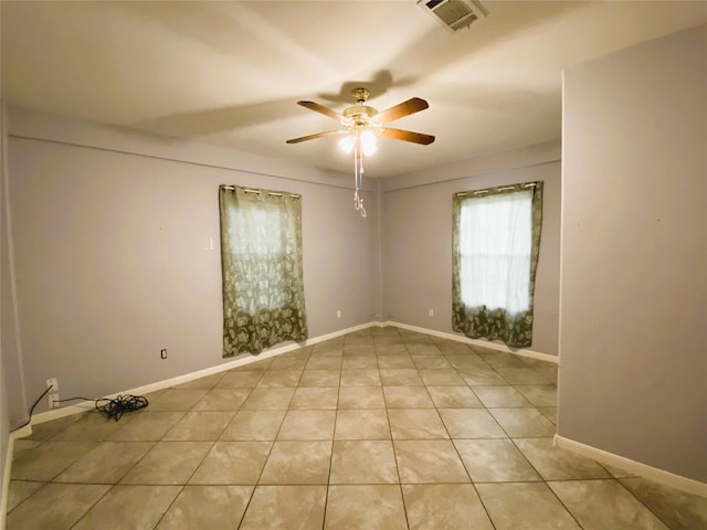 tiled spare room featuring ceiling fan