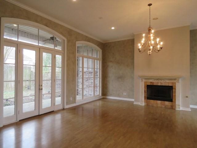 unfurnished living room with a wealth of natural light, a tile fireplace, and ornamental molding