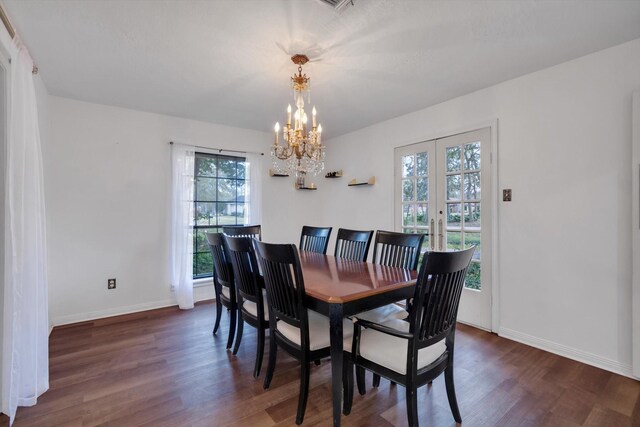 dining space with dark hardwood / wood-style floors, a notable chandelier, and a healthy amount of sunlight