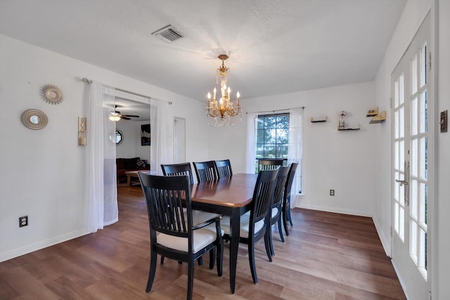 dining area with hardwood / wood-style flooring, a textured ceiling, and a notable chandelier