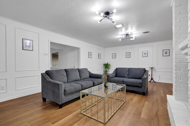 living room featuring wood-type flooring and a textured ceiling