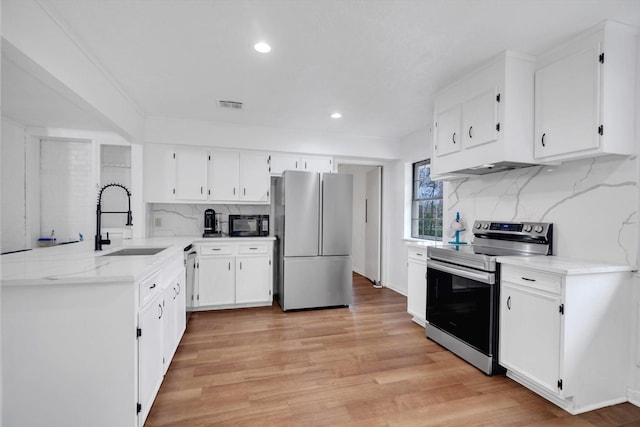 kitchen with sink, white cabinetry, backsplash, and stainless steel appliances