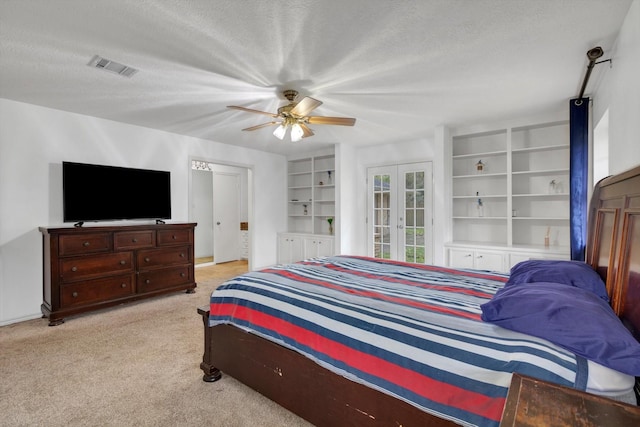 bedroom featuring ceiling fan, french doors, light colored carpet, and a textured ceiling