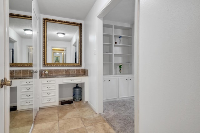 bathroom featuring built in shelves and vanity