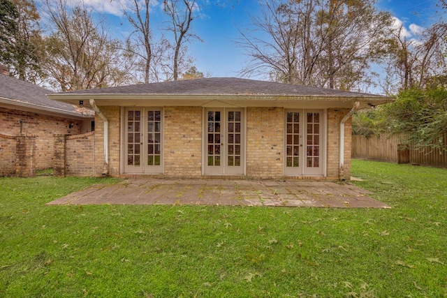 back of property with a patio area, a yard, and french doors