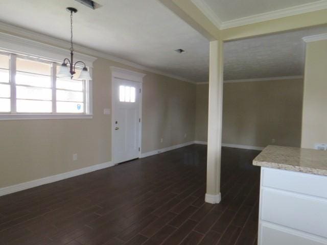 interior space with dark wood-type flooring, ornamental molding, and a chandelier