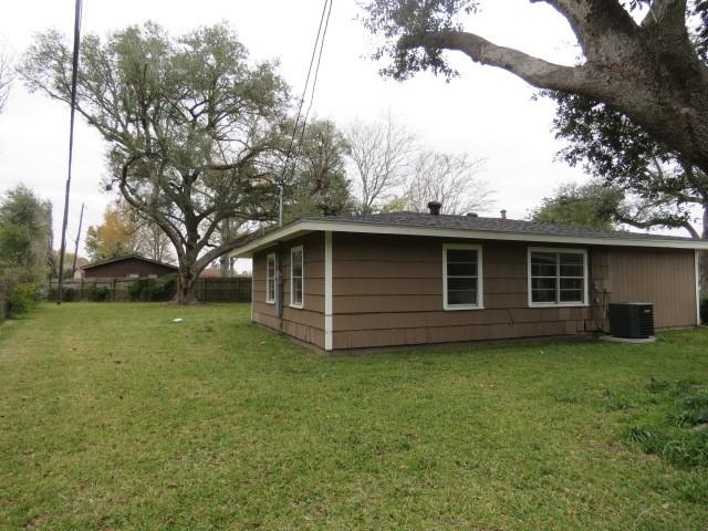 view of side of home featuring central air condition unit and a yard