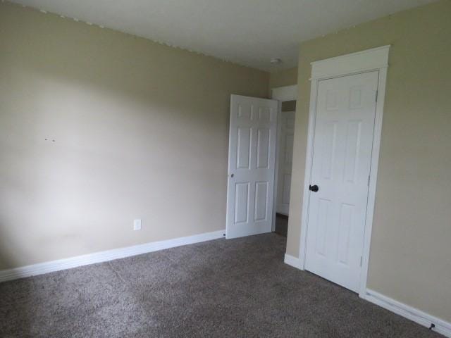 unfurnished bedroom featuring dark carpet