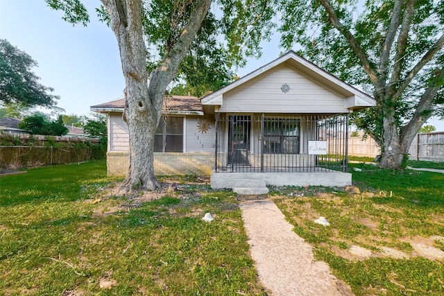 bungalow-style home featuring covered porch and a front yard