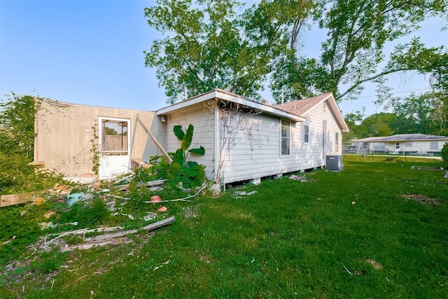 view of side of property with central air condition unit and a yard