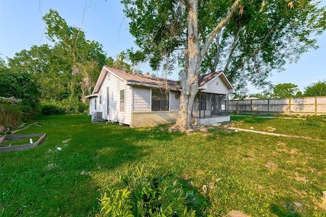 back of property with a lawn, central AC, and a sunroom