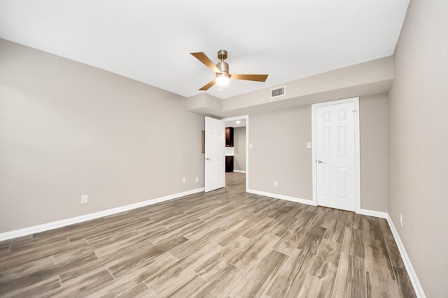 unfurnished bedroom featuring light hardwood / wood-style floors, a closet, and ceiling fan