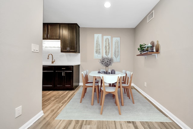 dining area featuring sink and light hardwood / wood-style flooring