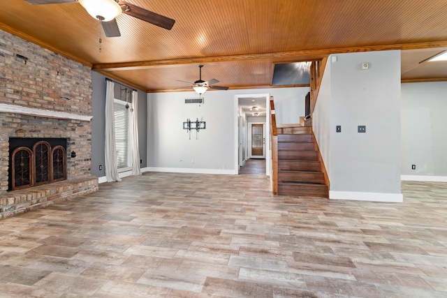 unfurnished living room with ceiling fan, beam ceiling, a fireplace, and wooden ceiling