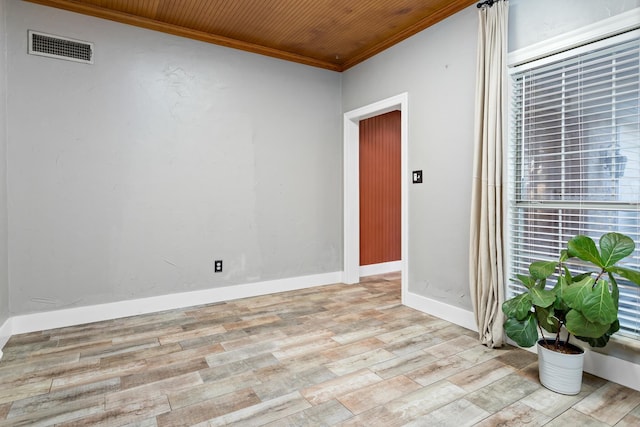 empty room featuring wooden ceiling, light wood-type flooring, and ornamental molding