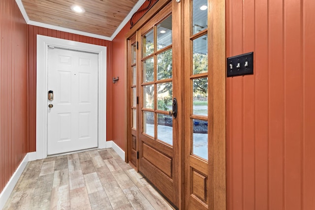 entryway with crown molding, light hardwood / wood-style floors, wooden walls, and wood ceiling