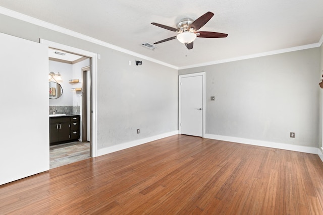 spare room with hardwood / wood-style flooring, sink, and crown molding