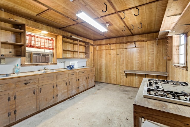 kitchen featuring wood walls, gas cooktop, sink, and wooden ceiling