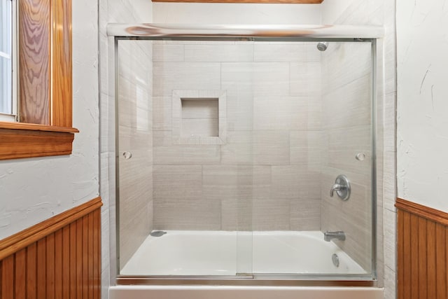 bathroom with shower / bath combination with glass door