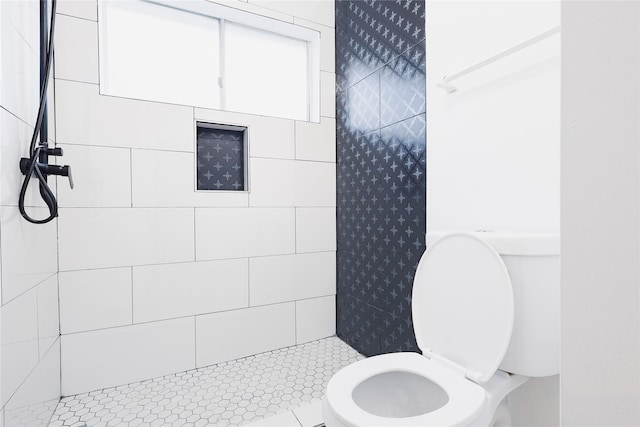 bathroom with toilet and a tile shower