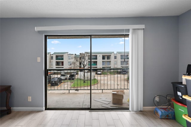 doorway to outside with a textured ceiling