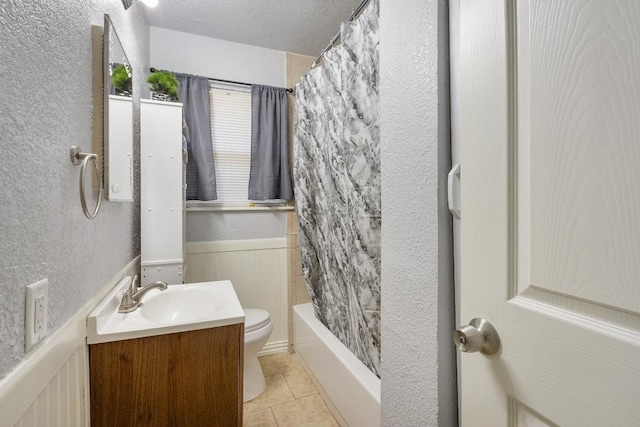 full bathroom with shower / tub combo, tile patterned floors, toilet, a textured ceiling, and vanity