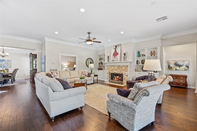 living room featuring built in shelves, ornamental molding, and dark wood-type flooring