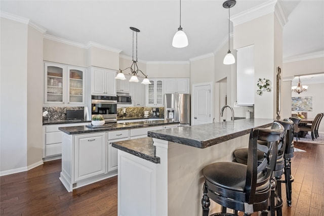 kitchen with white cabinetry, kitchen peninsula, appliances with stainless steel finishes, and decorative backsplash