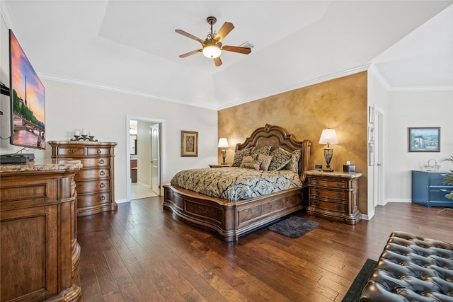 bedroom with dark hardwood / wood-style floors, ensuite bath, ceiling fan, and a raised ceiling