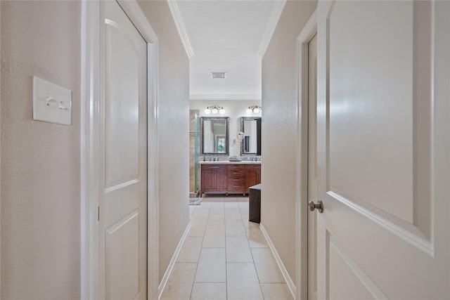 hall featuring crown molding and light tile patterned floors