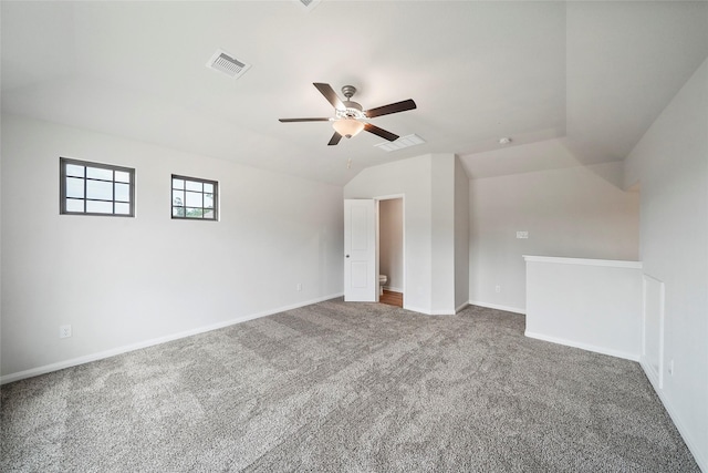 empty room with ceiling fan, vaulted ceiling, and carpet flooring