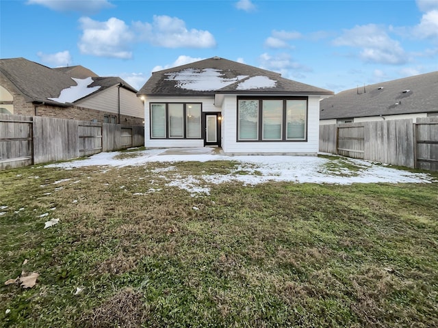 rear view of property with a lawn