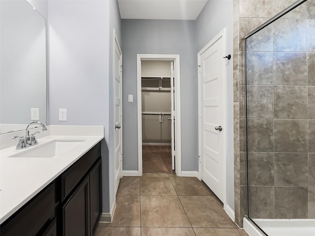 bathroom with a shower with door, tile patterned floors, and vanity