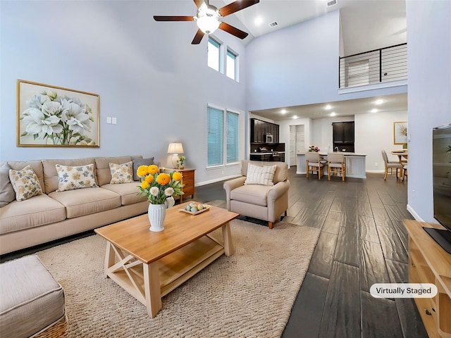 living room featuring ceiling fan and a high ceiling