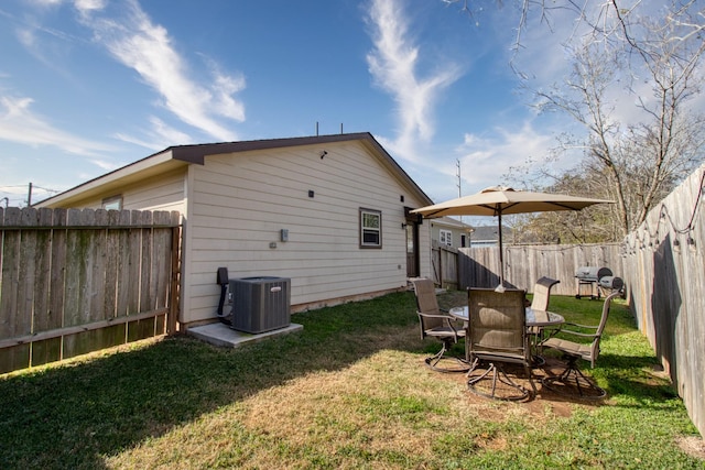 rear view of property with cooling unit and a lawn