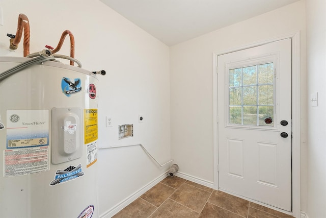 laundry area with laundry area, baseboards, tile patterned floors, electric water heater, and hookup for an electric dryer