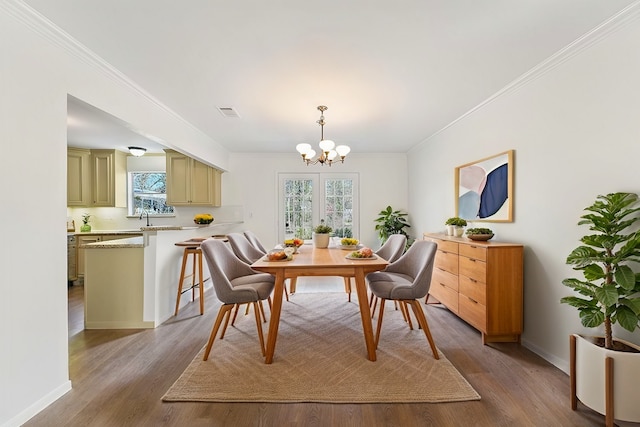 dining area featuring a notable chandelier, wood finished floors, and baseboards