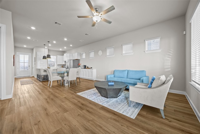 living room with ceiling fan, light hardwood / wood-style flooring, and a wealth of natural light