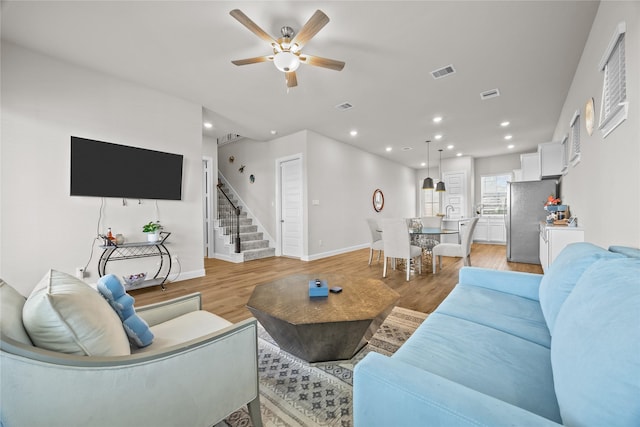 living room with ceiling fan and light hardwood / wood-style floors