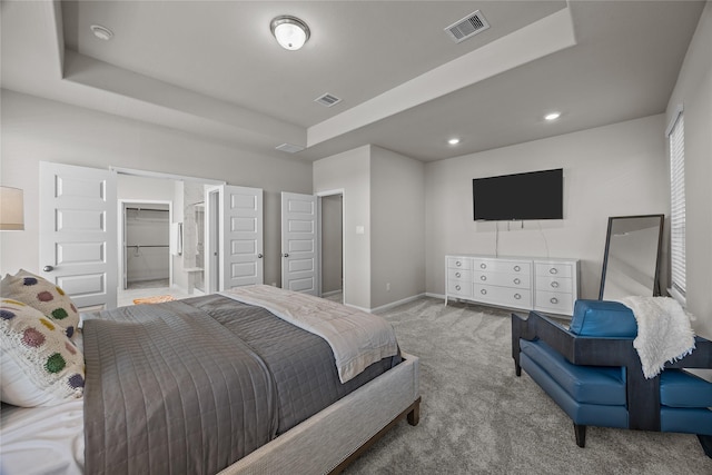 carpeted bedroom with a tray ceiling