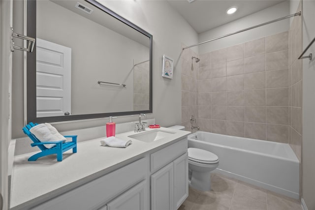 full bathroom with tiled shower / bath, vanity, toilet, and tile patterned floors