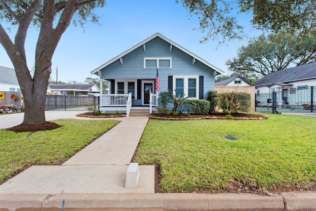 bungalow-style home with a front yard and covered porch