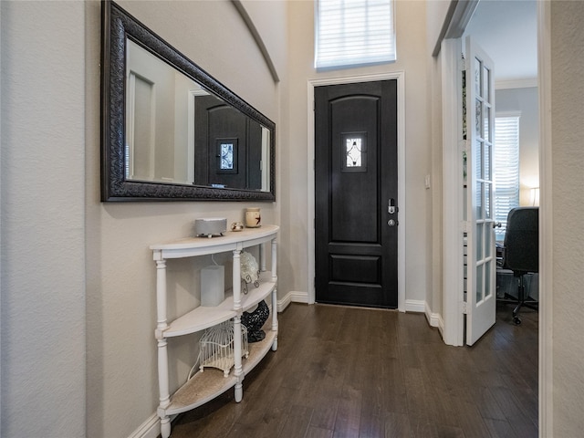 entryway with crown molding and dark wood-type flooring