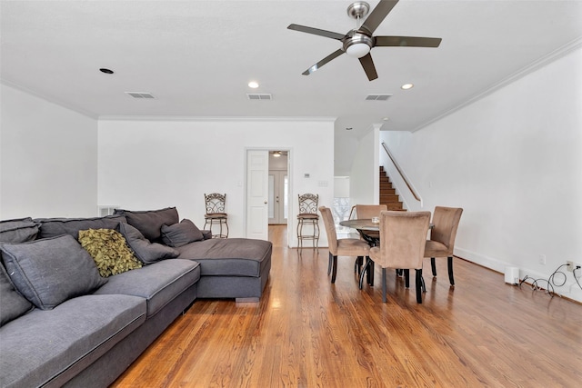 living room featuring ceiling fan, light hardwood / wood-style flooring, and crown molding