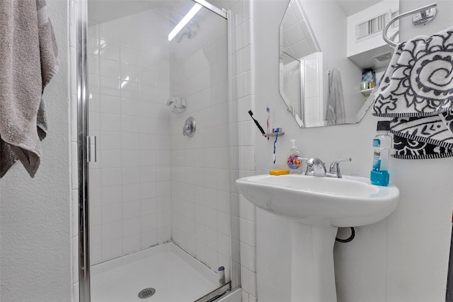 bathroom featuring sink and a shower with shower door