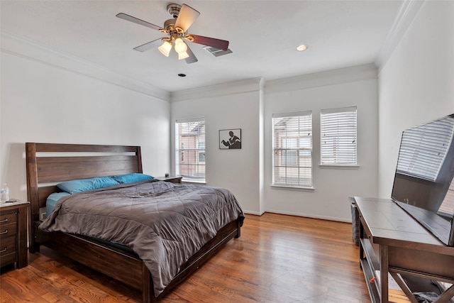 bedroom featuring ceiling fan, crown molding, and wood-type flooring