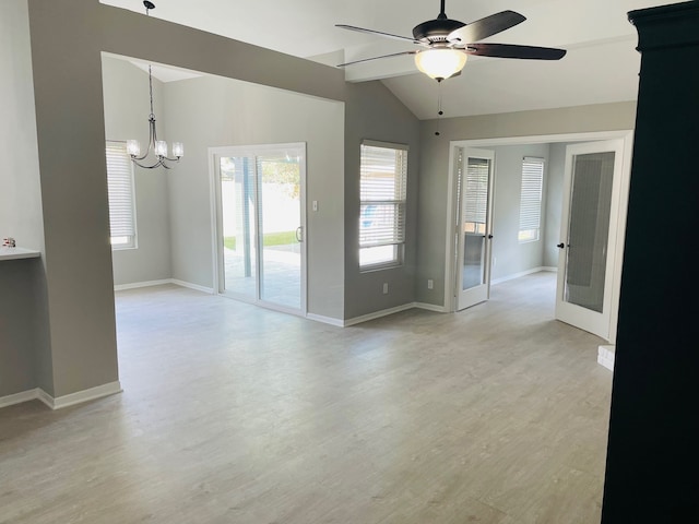 unfurnished room featuring lofted ceiling, ceiling fan with notable chandelier, and light wood-type flooring