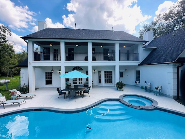 view of swimming pool with ceiling fan, a patio area, and an in ground hot tub