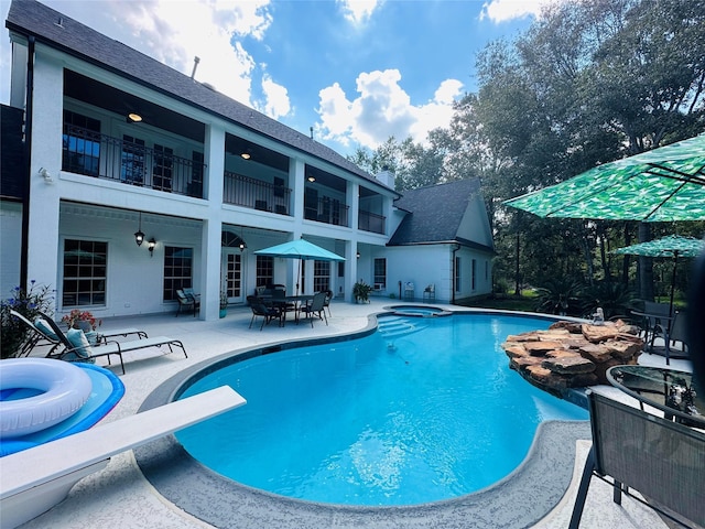 view of pool featuring an in ground hot tub, a patio area, and a diving board