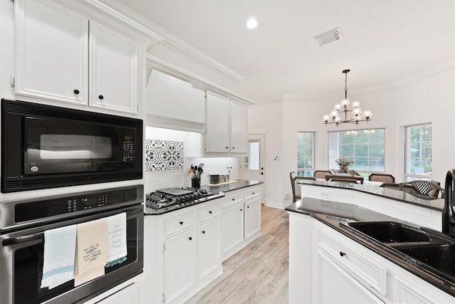 kitchen with premium range hood, black appliances, and white cabinets